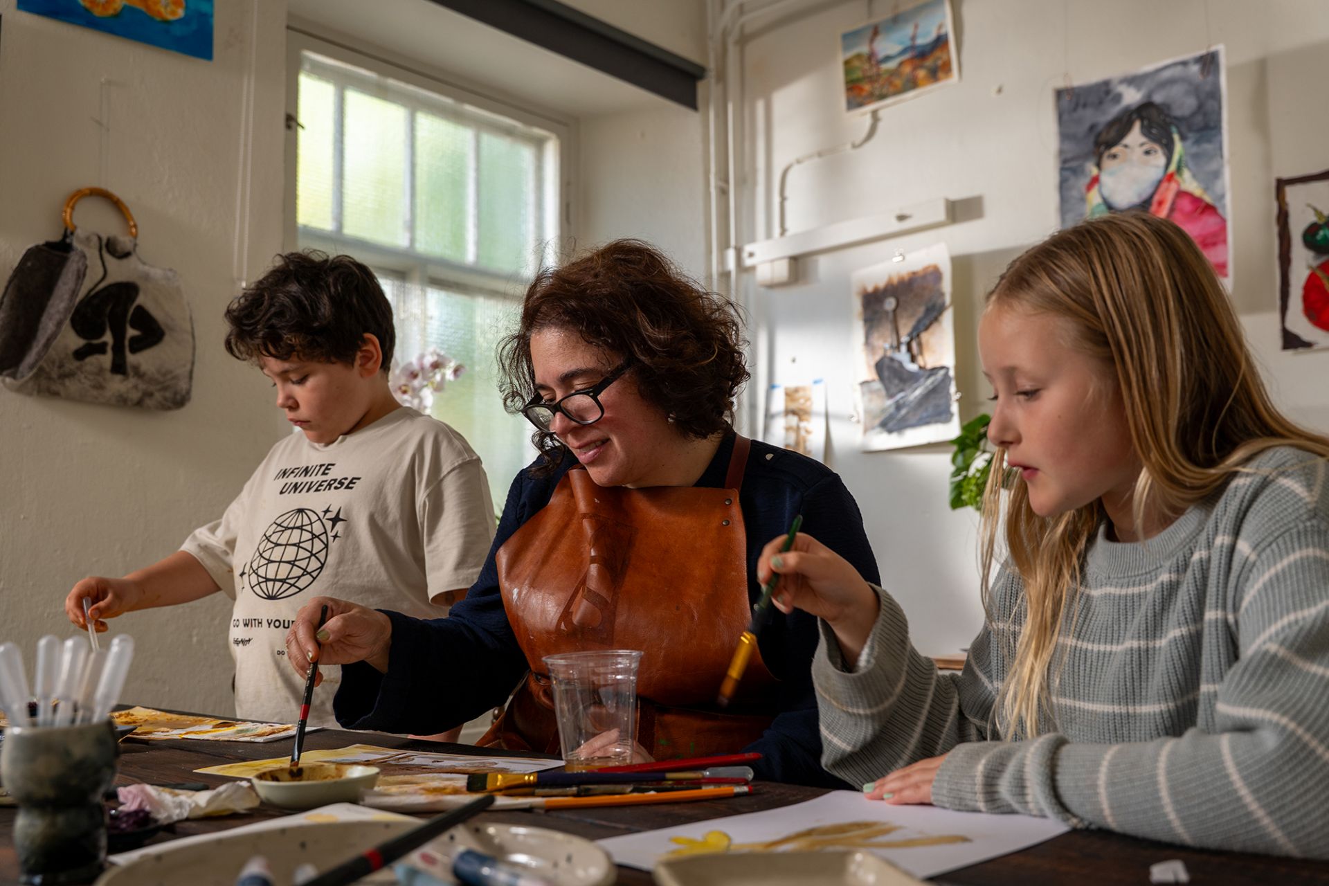 Alejandra Löthman och två barn gör konstens fredag uppgiften