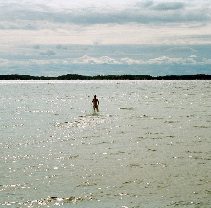 Konstrundan regionkontakt Västra Nyland Jani A. Purhonen, människofigur som står ut i havet. Fotografi: Laura Tuomi
