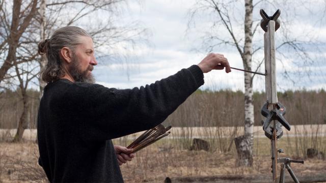 Zacheriah står ute och målar.